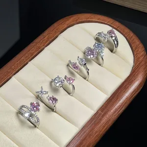 Detail view of elegant silver open rings with pink and white zircon stones in tray.