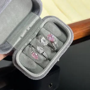 Elegant pear-cut pink and white zircon open rings in a gray velvet jewelry box