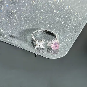 Macro view of adjustable silver ring featuring pink round stone and white zircon flower detail
