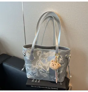 Bolso tote grande plateado metalizado con un encantador detalle de colgante de oso