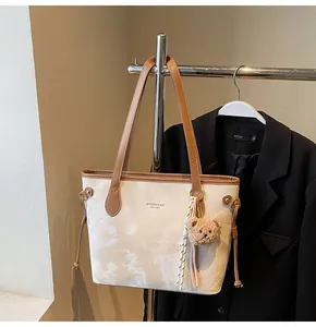 Vista detallada del bolso tote grande para mujer con patrón de mármol y llavero de oso.