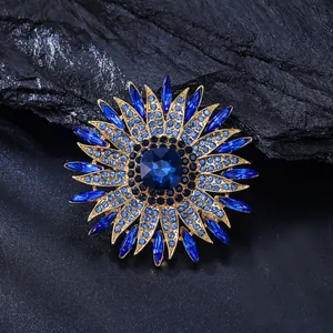 Detailed view of a golden sunflower brooch adorned with vibrant blue crystals