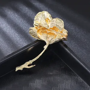 Detail view showing the back and secure pin clasp of an elegant gold ginkgo leaf brooch.