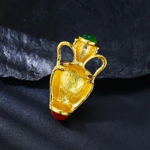 Detailed back view of vintage French gold vase brooch with green and red stones