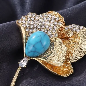Luxury ginkgo leaf brooch with turquoise and crystals on black satin backdrop