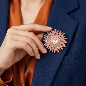 Elegant pink crystal sunflower brooch pinned on a navy blue blazer lapel for party