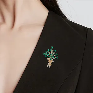 Macro detail view of an elegant green crystal flower bouquet brooch on a black blazer.