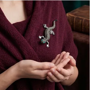 Vintage lizard brooch with sparkling rhinestones on elegant knit sweater