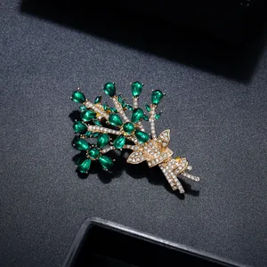 Close-up of elegant flower bouquet brooch featuring green gems and golden metal
