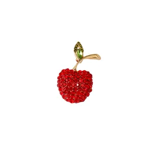 Sparkling red rhinestone apple brooch with green leaf detail in gold-tone alloy