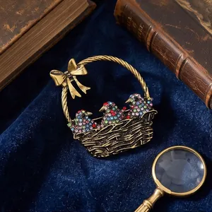 Vintage gold-tone metal basket brooch with colorful crystal birds on deep blue velvet background