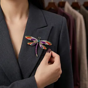 Vibrant dragonfly brooch with colorful enamel and crystals on a grey blazer.
