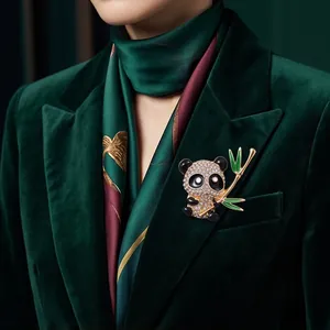 Eleganter Panda-Anstecknadel mit Strasssteinen auf einem grünen Samtjackett