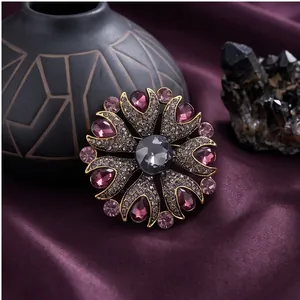 Eleganter Vintage-Blumenbrosche mit lila Kristallen und grauem Stein auf Seidenhintergrund