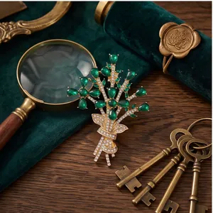 Luxury vintage gold floral bouquet brooch featuring green pear gemstones and crystals.