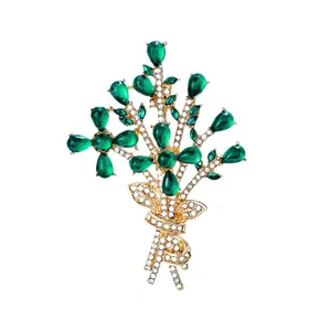 Elegant gold bouquet brooch with green teardrop stones and sparkling rhinestones