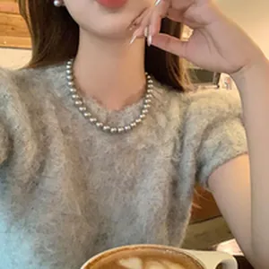 Elegant gray glass pearl necklace for women shown on a model with a cozy sweater