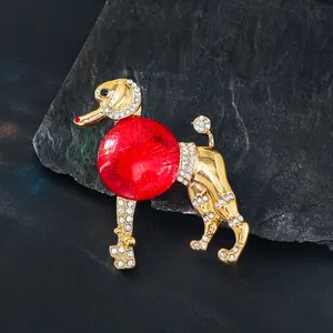 Détail exquis d'une broche caniche vintage avec pierre de verre rouge et strass dorés