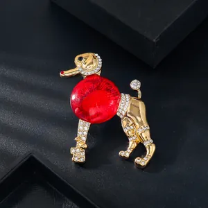 Gros plan d'une broche caniche vintage élégante avec corps en verre rouge et strass.