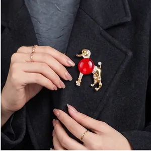 Broche caniche vintage élégante avec verre rouge et cristaux sur un manteau noir.