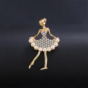 Detailed close-up of a gold ballerina brooch featuring sparkling rhinestones and pearls.