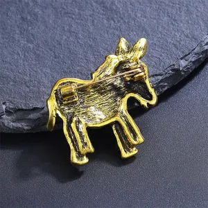 Detail view of the back of a vintage gold donkey brooch showing secure pin closure.