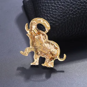 Achterkant detail van een gouden olifant broche met veiligheidsspeld en textuur.