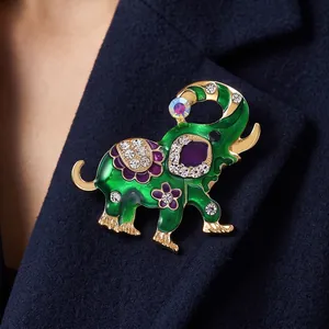 Luxe groene emaille olifantenbroche met sprankelende kristallen op een pakrevers