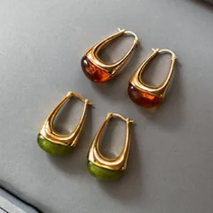 Elegant vintage gold-tone oval hoop earrings featuring amber and green resin stone accents
