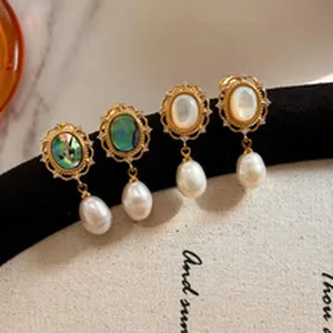 Close-up of vintage palace style oval earrings with mother of pearl and drop pearls