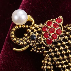 Prachtige vintage gouden olifant broche met rode strass steentjes en een elegante witte parel