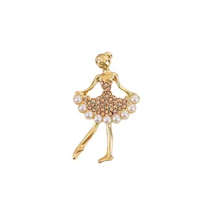 Elegant golden ballet dancer brooch embellished with rhinestones and pearls on white background