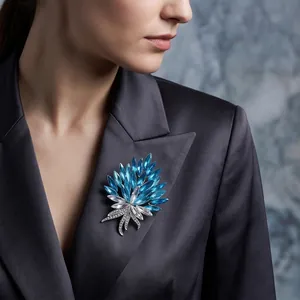 Broche de ramo de cristal azul de lujo prendido en la solapa de un blazer de satén
