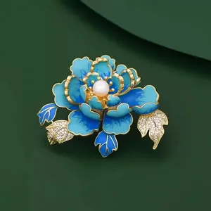 Macro view of an elegant blue enamel peony flower brooch featuring a pearl center and crystals.