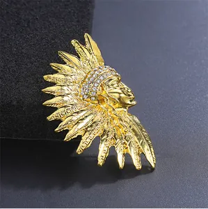 Macro view of vintage gold-tone chieftain brooch featuring intricate patterns and crystals.