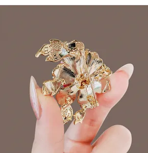 Detailed back view of a gold peony flower brooch showing the secure pin fastener.