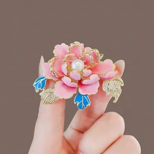 Close-up of elegant peony flower brooch with pink enamel and center pearl detail