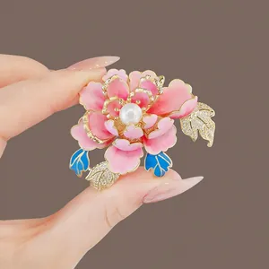 Close-up of elegant pink enamel peony flower brooch with pearl and crystal detail