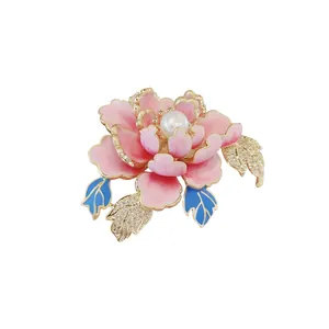 Close-up of pink peony flower brooch featuring a central pearl and crystal leaves