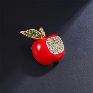 Close-up detail of a vibrant red apple brooch featuring sparkling green and clear rhinestones