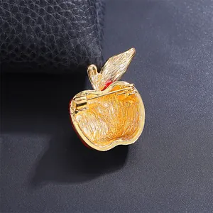 Macro detail of the golden textured back and pin clasp of an apple fruit brooch