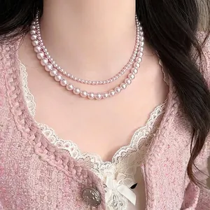 Detail einer eleganten zweisträngigen rosa Glasperlenkette für einen edlen Sommer-Look