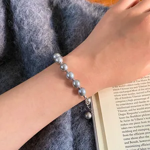 Elegant grey glass pearl bracelet with 24k gold plating worn on wrist for women