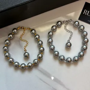 Two elegant heather gray glass pearl bracelets with gold and silver plated metal accents