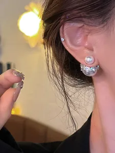 Vue détaillée de boucles d'oreilles perles double face avec couronne argentée.