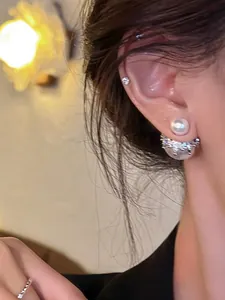 Vue détaillée d'élégantes boucles d'oreilles perles double face avec couronne en métal argenté