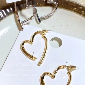 Minimalist gold heart-shaped crossover stud earrings for women with elegant design