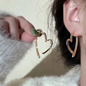 Elegant gold heart-shaped earrings with minimalist crossover design for women