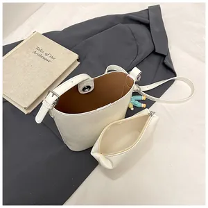 Detailed view of white bucket bag with inner pouch and adjustable strap
