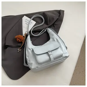 Borsa hobo azzurra alla moda con tasca a fibbia e charm orsetto di peluche
